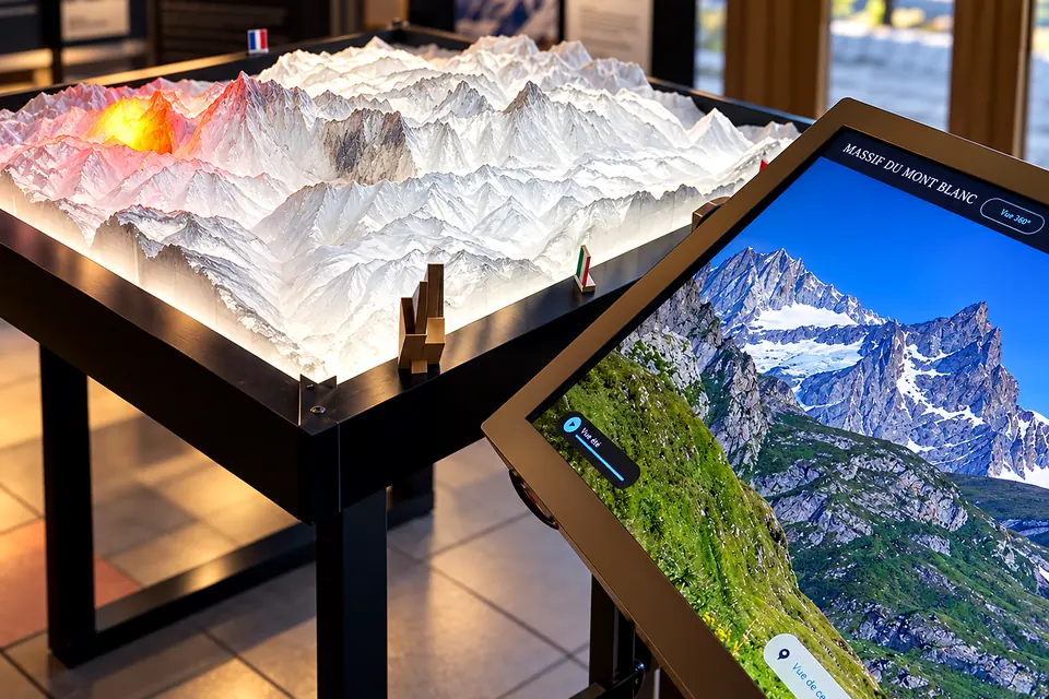 Le sommet du Mont Blanc allumé, à côté d'une borne d'information
